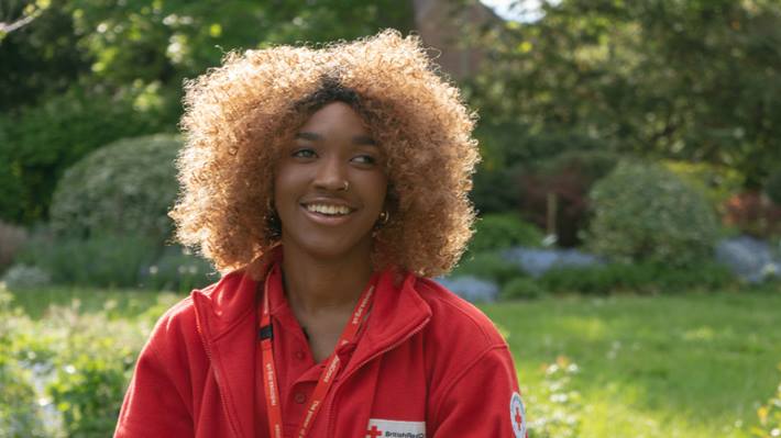 Two Red Cross volunteers wearing branded Red Cross t-shirts and laughing together
