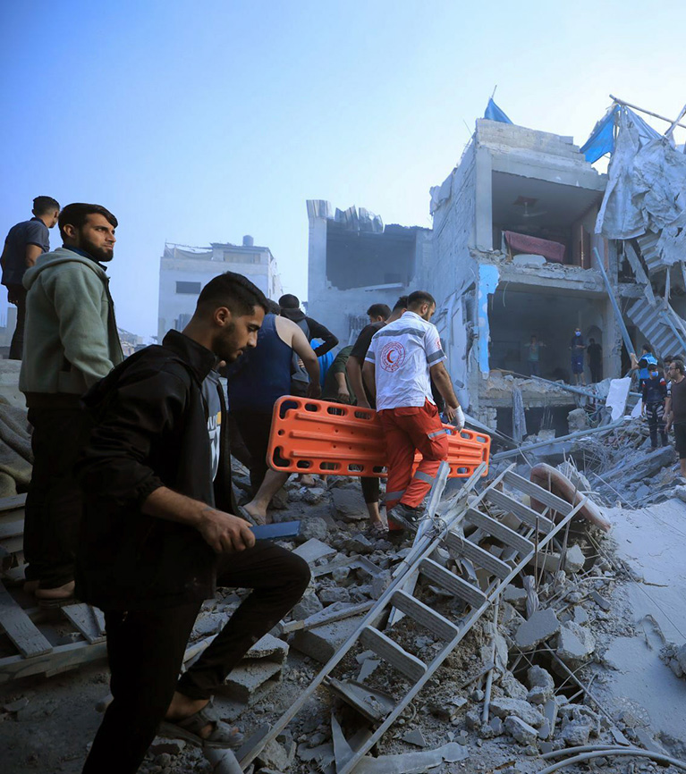 Palestine Red Crescent Society teams carry stretcher through rubble to provide medical aid in Gaza.