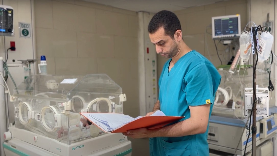 Dr. Mohamed Al-Deeb Palestine Red Crescent Society at Al Quds Hospital in Gaza City looking at a chart next to an incubator