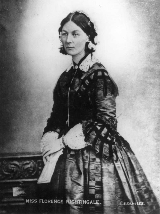 Black and white photo of a lady standing in regal clothes