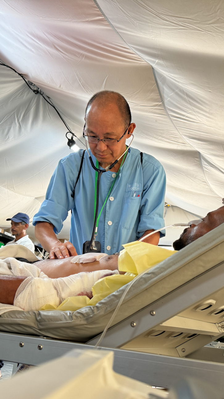 Surgeon doing the morning round with a patient on a bed.