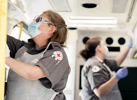 Two members of the ambulance support team disinfect an ambulance.