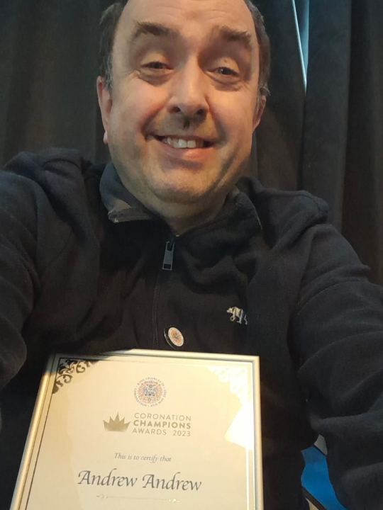 Andrew Longhurst smiles for the camera with his coronation champion certificate.