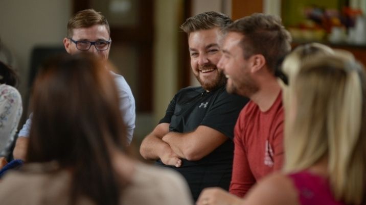 Presenter Alex Brooker laughs with friends at a British Red Cross first aid course
