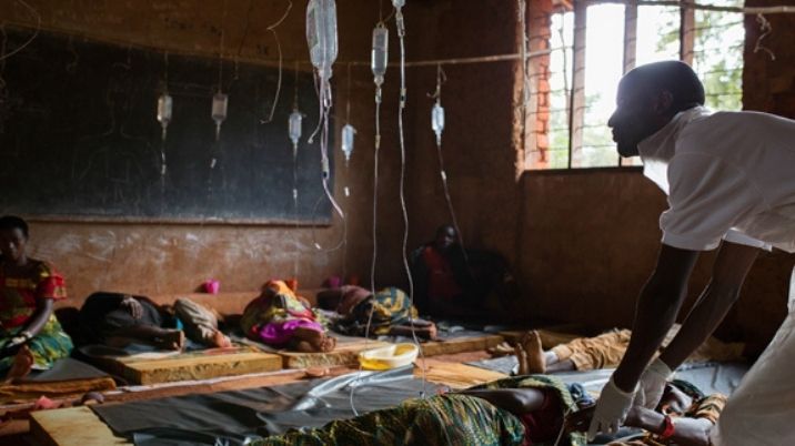 A man providing vital fluids at a cholera treatment centre.