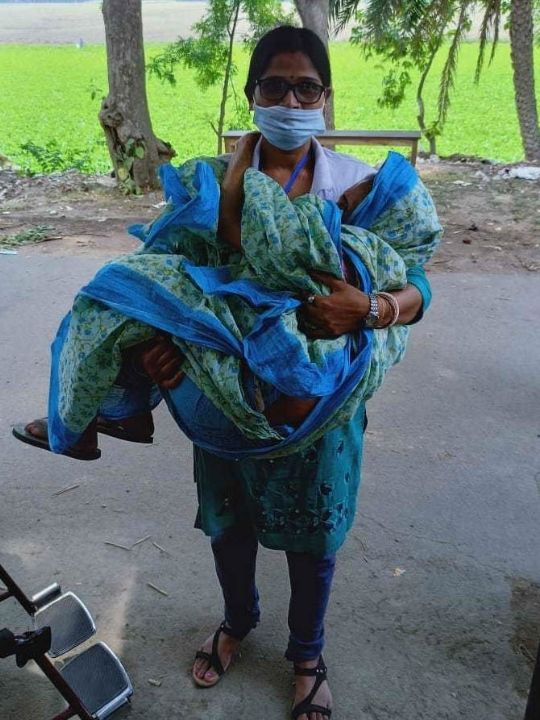 A woman carries her ill relative during the coronavirus pandemic in India.