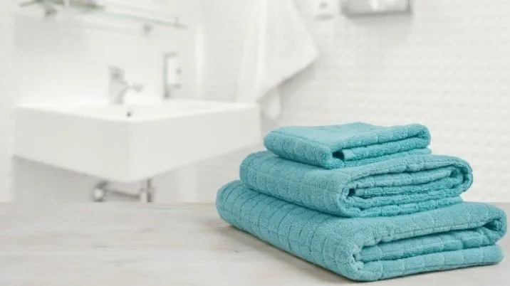A stack of towels in a white bathroom from a British Red Cross blog about how ordinary items can save lives.