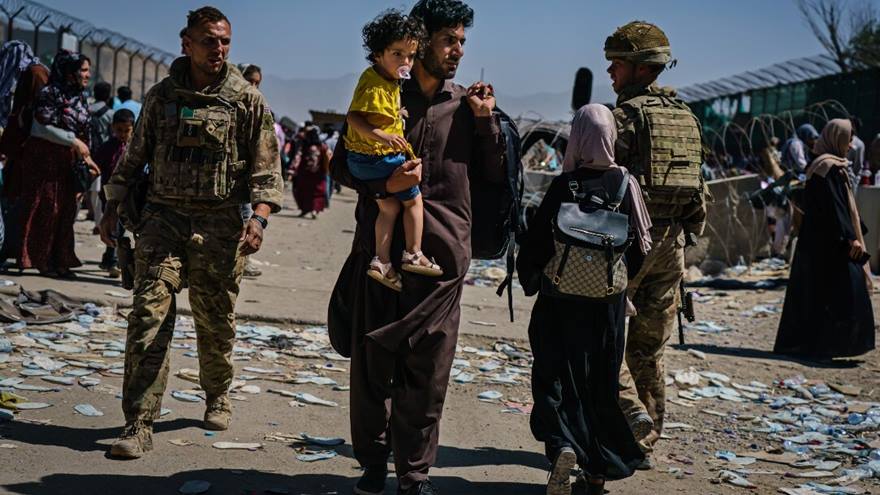 Afghan refugees make their way towards an intake near Abbey Gate, as British and American security forces maintain order amongst the Afghan evacuees waiting to leave, in Kabul, Afghanistan