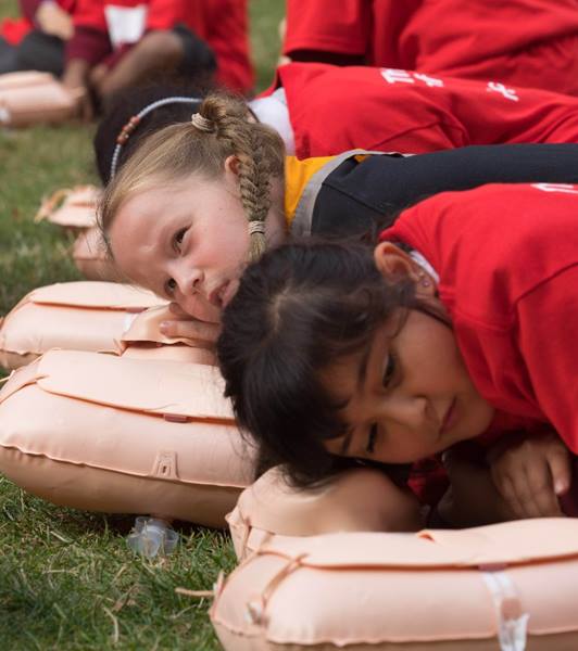 Children practice first aid on a dummy