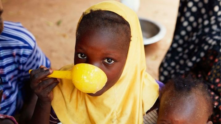 A little girl eats some food in the village of Keiche, southern Niger.