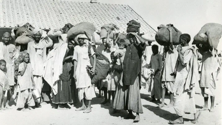 A black and white photograph showing refugees arriving in Lahore during the Partition