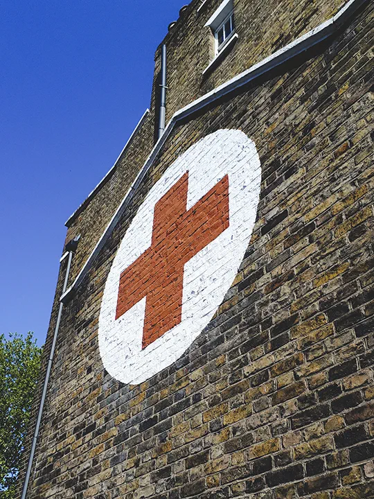 British Red Cross emblem displayed on the outside wall of the refugee centre in Hackney