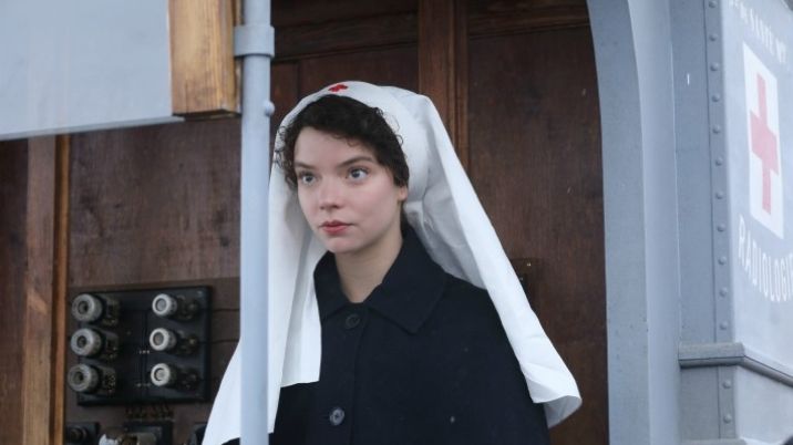 A still from the film 'Radioactive', depicting Irene Curie, played by Anya Taylor Joy who is dressed as a British Red Cross nurse, with the Red cross symbol in the background.