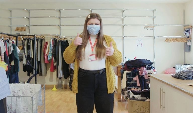 British Red Cross shop volunteer with thumbs up