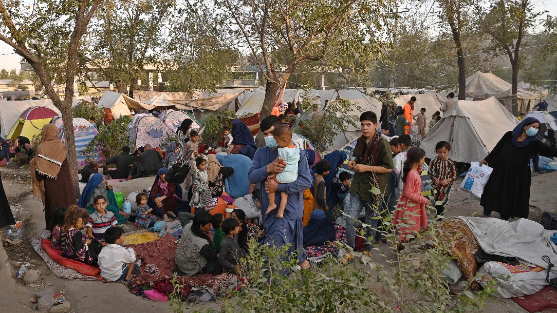 Internally displaced Afghan families, who fled from Kunduz, Takhar and Baghlan province, sit in front of their temporary tents at Sara-e-Shamali in Kabul on August 11, 2021.
