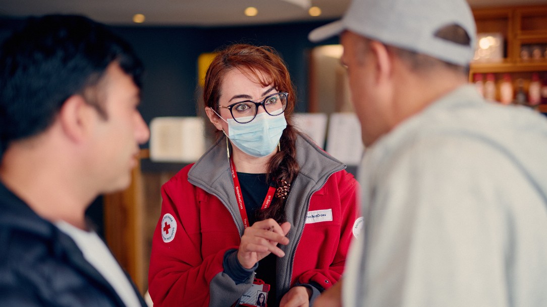 A British Red Cross volunteer greets people at the airport
