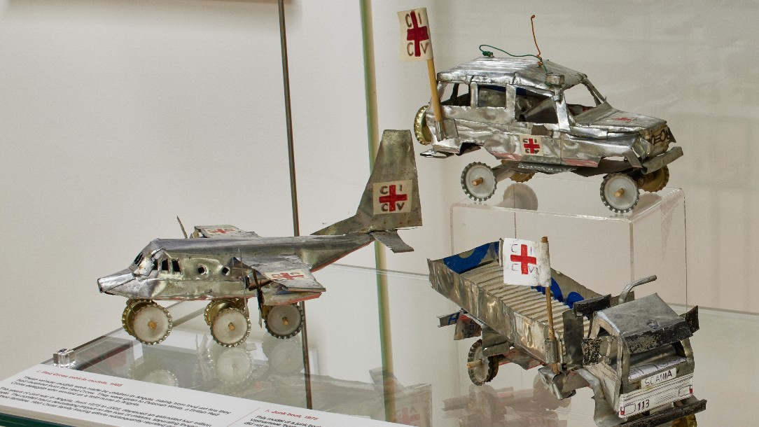 Miniature vehicle models made by children in Angola, mainly out of Red Cross food aid tins.