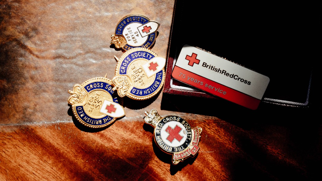 A selection of British Red Cross badges seen placed on a table