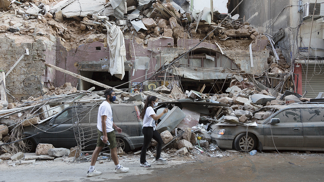 Two people walk past the devastating aftermath of the enormous explosion in Beirut. 