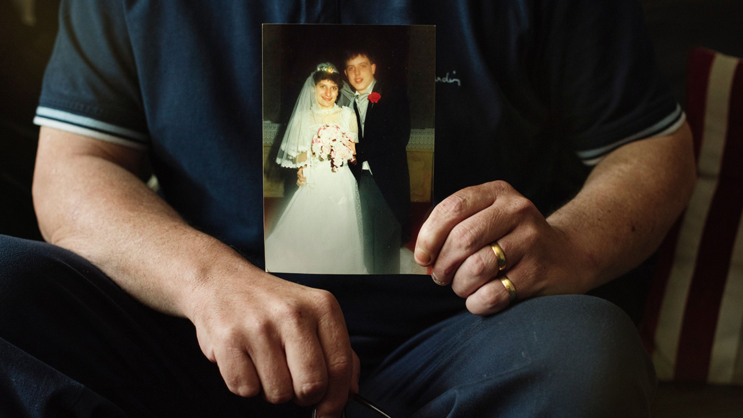Wayne O'Hanlon holding a photograph of himself and his wife on their wedding day.