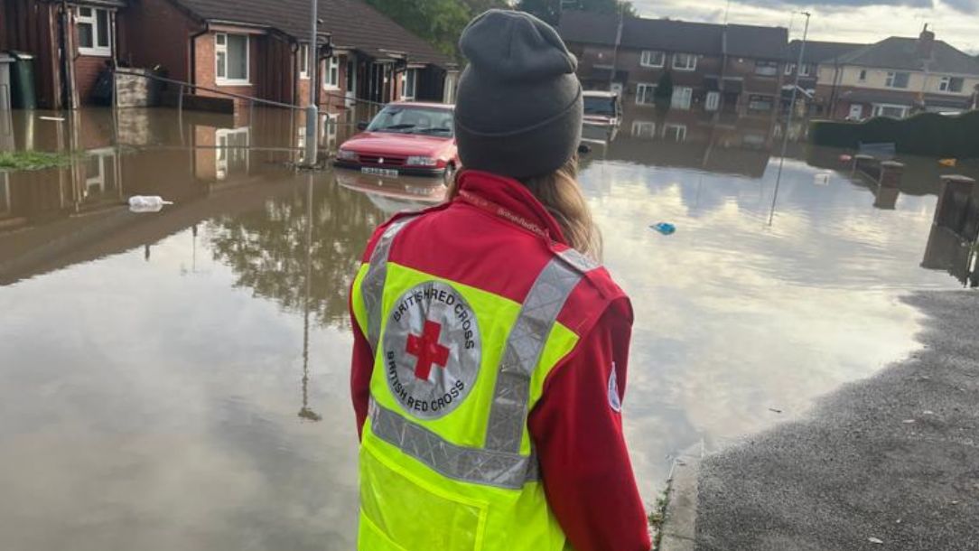 A British Red Cross worker approaches a flooded car in Rotheram