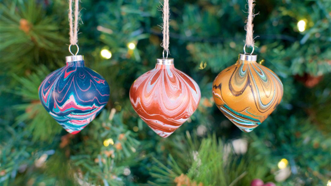 Christmas tree baubles designed by refugees through the British Red Cross hang on a Christmas tree.