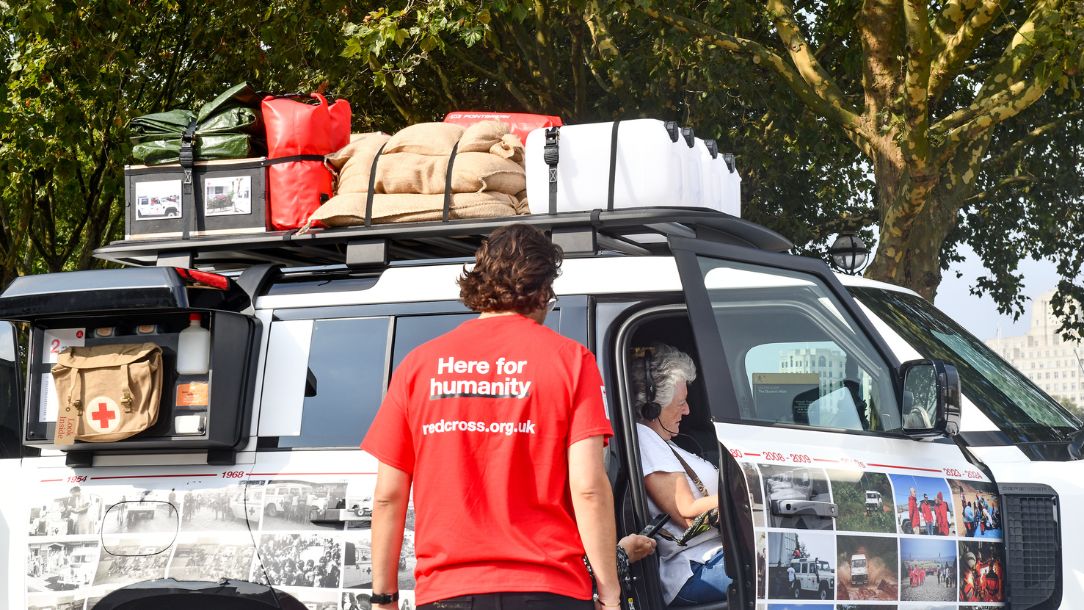 Defender vehicle showing side mounted gear carrier used during humanitarian relief efforts.
