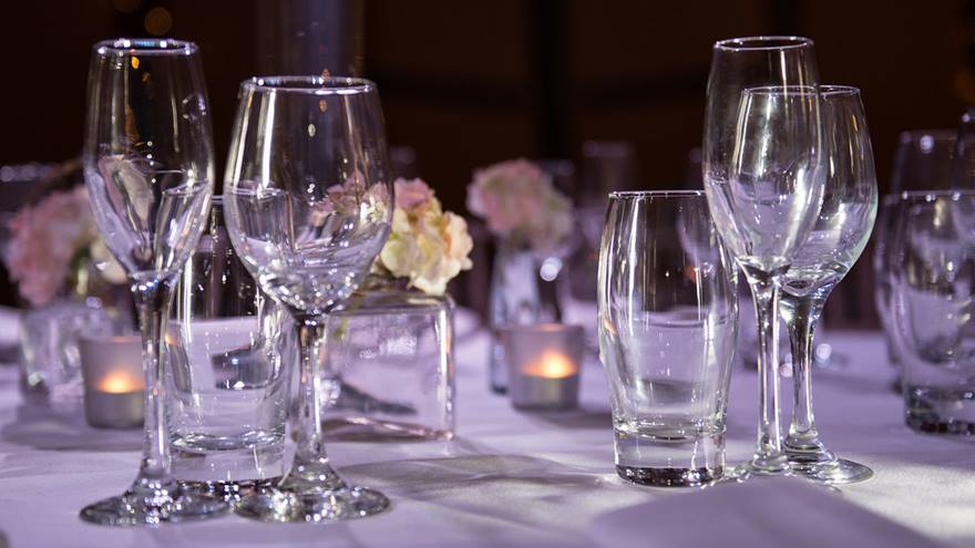 Wine glasses laid out on a dinner table.