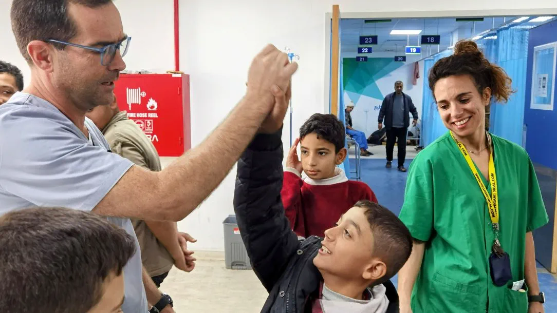 Internally displaced children have a brief moment of fun with an ICRC surgeon in Gaza.