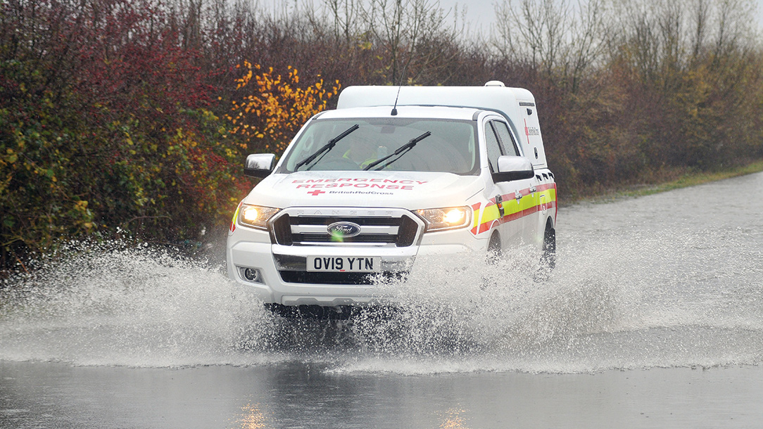 British Red Cross ambulance driving through flooded road