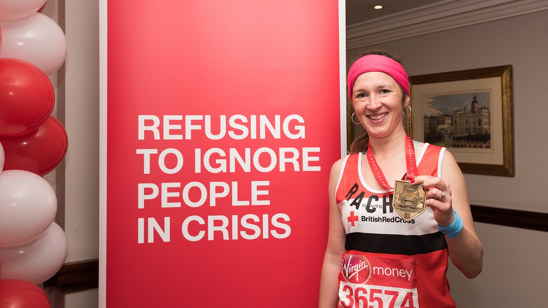 Lady holding up her medal after completing the event.