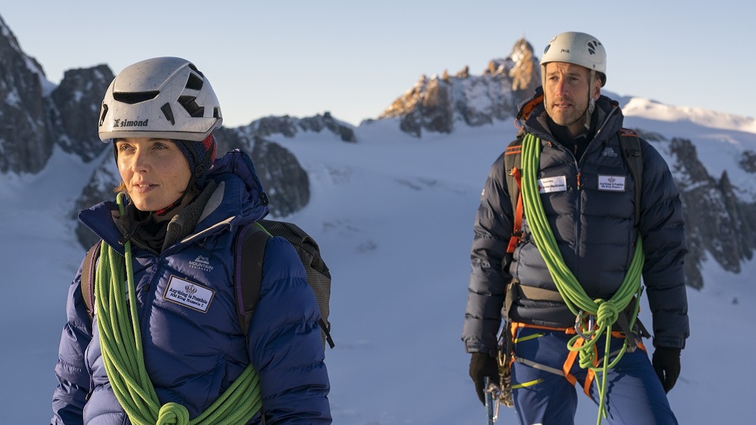 man and woman in hiking gear on a snowy mountain
