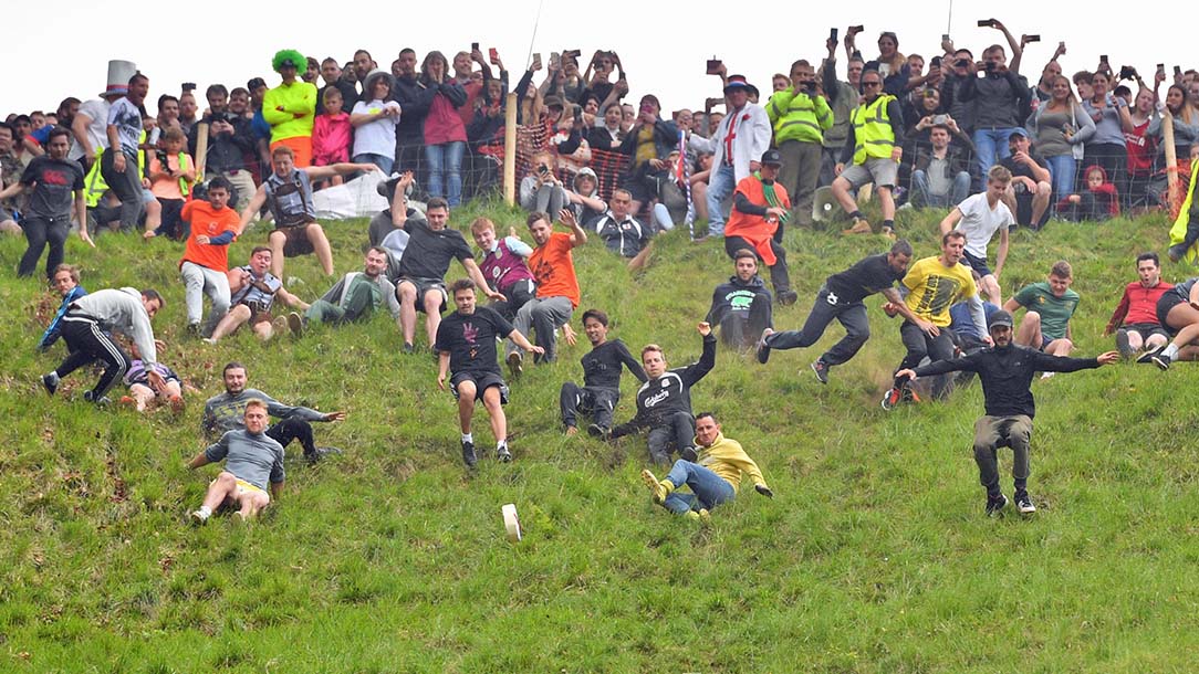 A crowd watching people take part in a cheese rolling competition.