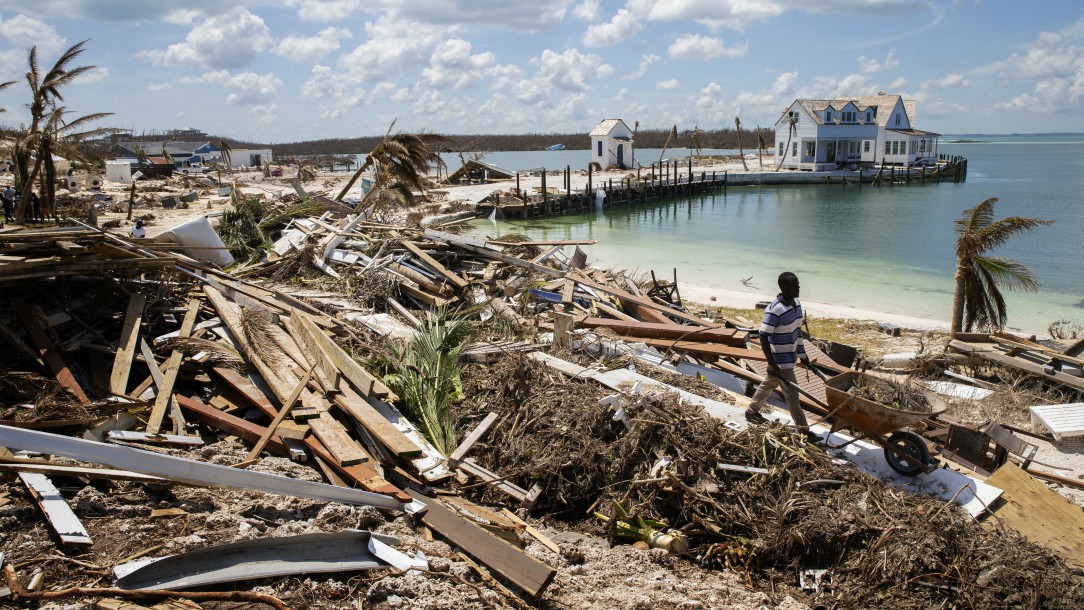 A man pushes a wheelbarrow through a huge area of land and homes badly damaged by Hurricane Dorian in the Bahamas.