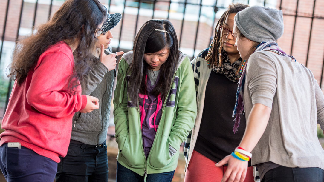 A group of teenage girls bully another girl.