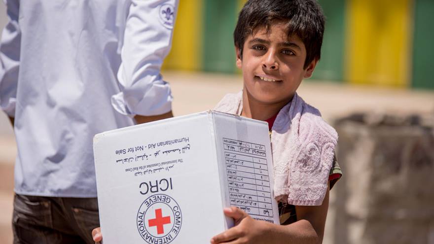 A boy holding an aid parcel.