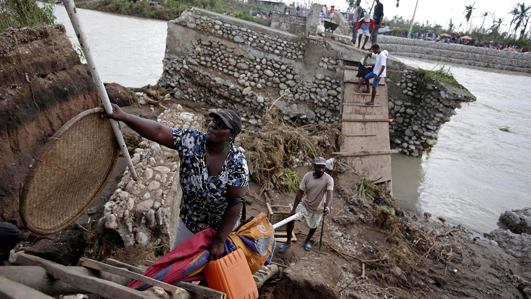 People in Haiti use a handmade ladder after a bridge has been destroyed by Hurricane Matthew.