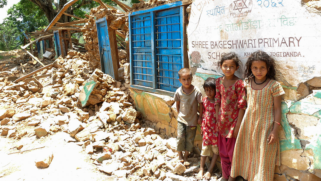 Children standing in the aftermath of an earthquake