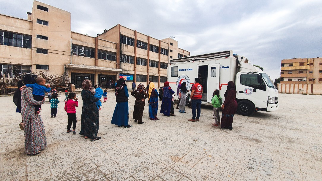 People queue for a mobile health clinic in Hassakeh, Syria