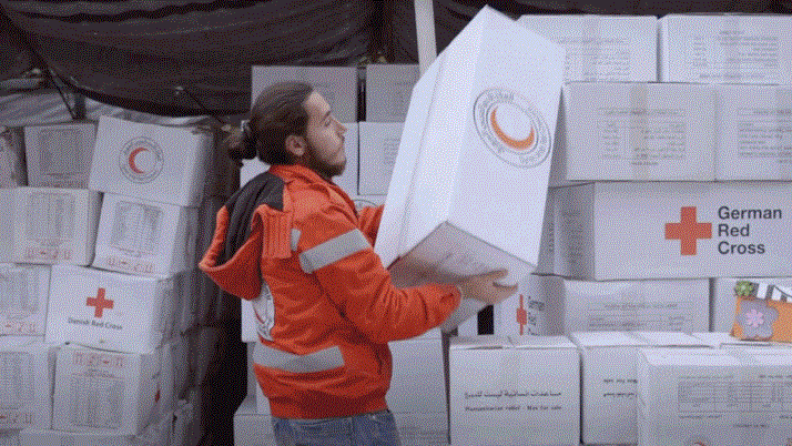 Syrian Arab Red Crescent volunteer, Wasam, hands out hygiene kits to people affected by the Syrian crisis.