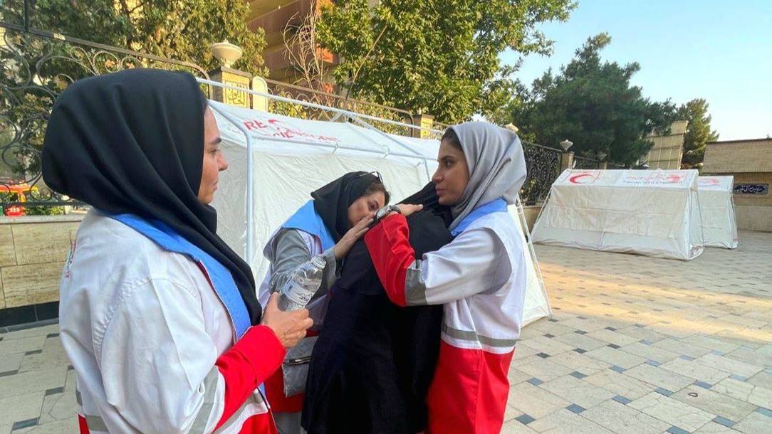 Iranian Red Crescent Society workers offer emotional support to a woman.
