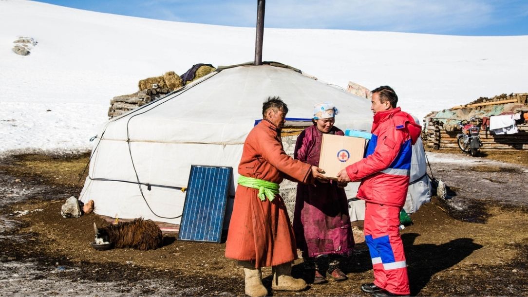 A Mongolian Red Cross worker provides vital supplies to a Mongolian herder to help them through the dzud.