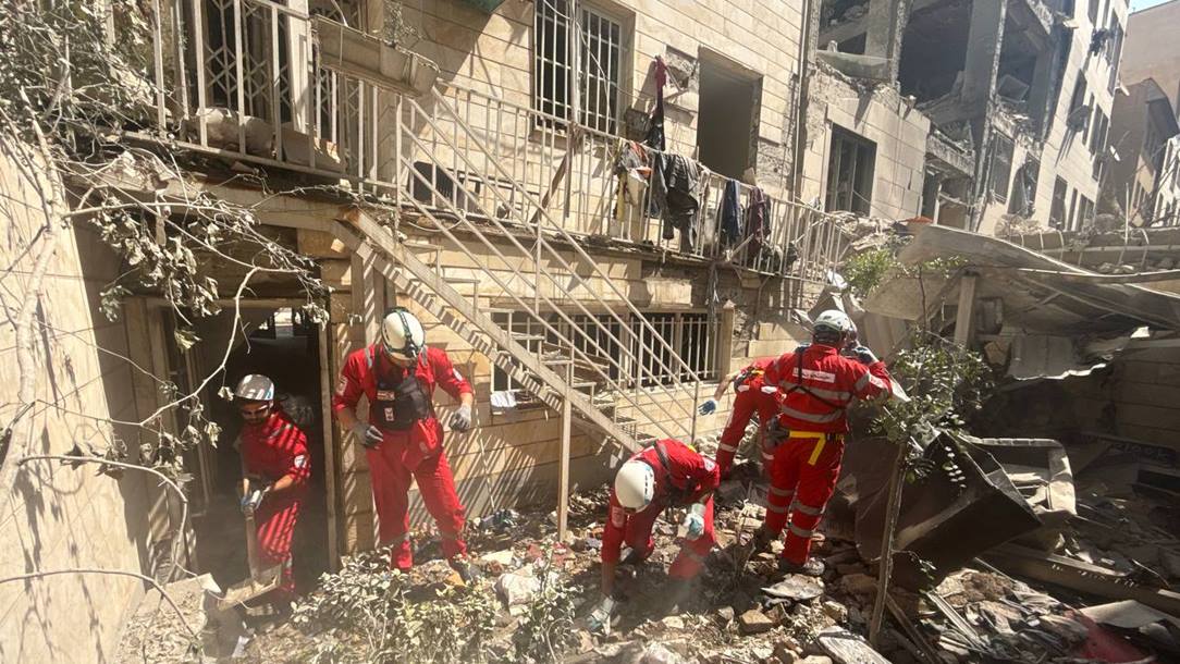 Iranian Red Crescent Society rescue workers attend a partially collapsed building.