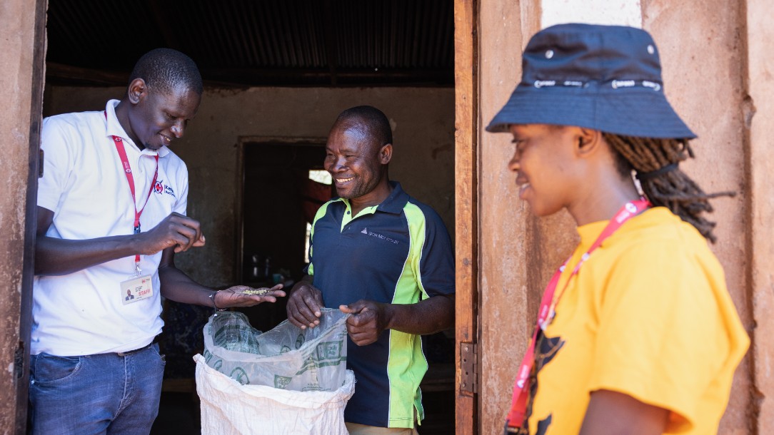 Joram, a Red Cross country coordinator in Kenya, stands with Kizaro, a farmer, and his colleague, Susan