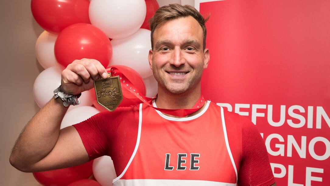 A man holding medal after completing event