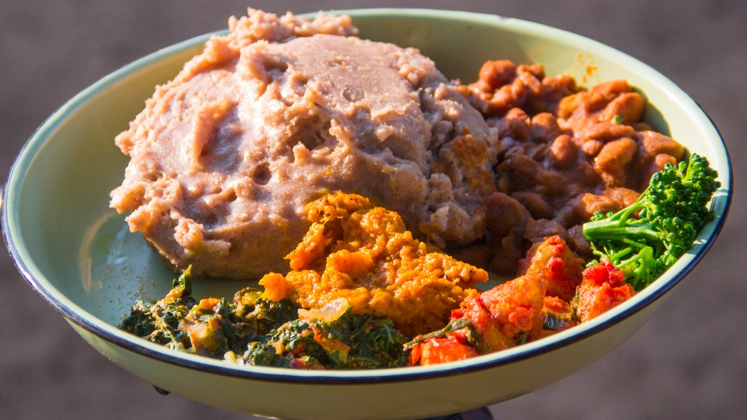 A plate of food including beans and broccoli cooked from ingredients sourced in the Chibuwe Health Clinic garden