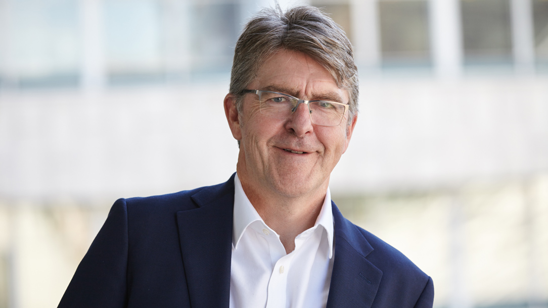 Mike Adamson wearing suit smiling for the camera.