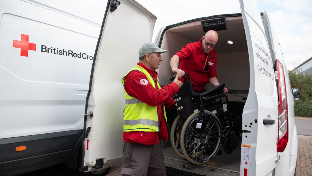 A man unloads a wheelchair from a British Red Cross van, at our mobility aids service in Harlow, Essex