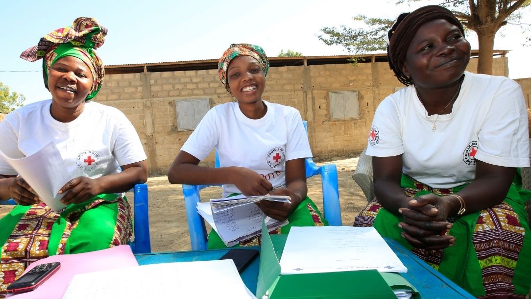 A group of smiling women conduct a mothers' club meets in Chad 