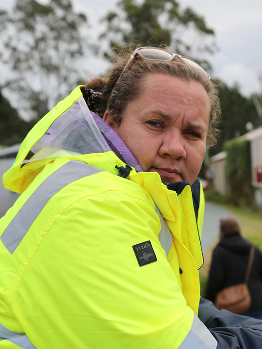 Sherrie, who received grants to buy essentials from the Red Cross after the Australian bush fires, leans against a railing and looks into the camera.